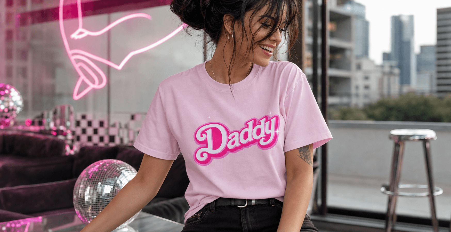 Model wearing a pink Not Necessarily Apparel graphic tee in a modern lounge